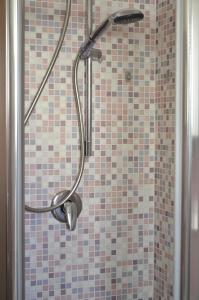 bagno con doccia e pareti piastrellate di Il Sestante Santa Marinella a Santa Marinella