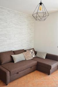 Sofá marrón en la sala de estar con lámpara en Il Sestante Santa Marinella, en Santa Marinella