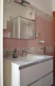 a white sink in a kitchen with pink tiles at Il Sestante Santa Marinella in Santa Marinella