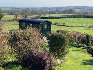 a green train car sitting in the middle of a field at Corner House in Cudworth