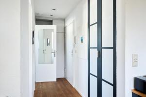 a hallway with white walls and a glass door at Ferienwohnung Ostseeperle Moba-Travel in Travemünde +6 photos