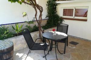 una mesa y sillas en un patio en Rural cottage in holiday park with 55 m2 pool en Tolox