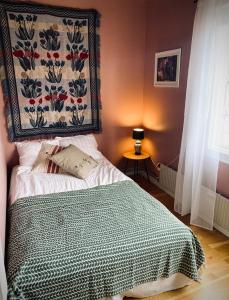 a bedroom with a bed and a tapestry on the wall at Villa Sol B&B and Hostel in Borgholm
