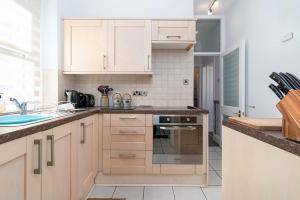 a kitchen with wooden cabinets and a stove top oven at Sandbanks in Deganwy