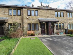 a brick house with a lawn in front of it at Avaelie Too in Hebden Bridge