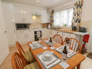 a kitchen and dining room with a wooden table and chairs at Avaelie Too in Hebden Bridge