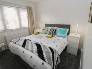 a bedroom with a large bed with blue pillows at Avaelie Too in Hebden Bridge