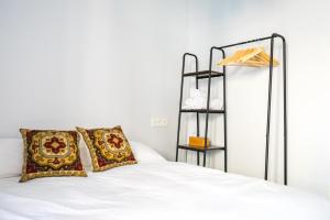 a bedroom with a white bed with pillows and a shelf at Villa Covadonga by beBalmy in Pedruño