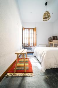 Un dormitorio con una cama y una mesa sobre una alfombra en Villa Covadonga by beBalmy, en Pedruño