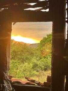 BorowoにあるКъща за гости Вино от глухарчетаの日没を望む古い建物の窓