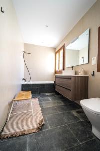 a bathroom with a sink and a toilet and a mirror at Villa Covadonga by beBalmy in Pedruño