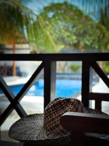 un sombrero sentado en una silla frente a una ventana en Hakuna Matata Resort Gili Air, en Gili Air