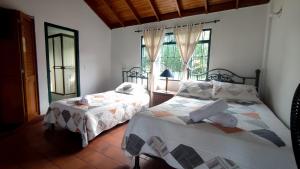 1 dormitorio con 2 camas y ventana en New Paradise Casa Campestre, en Villeta