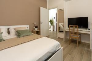 una camera con letto e scrivania con TV di Terre d'aMare Liguria a La Spezia