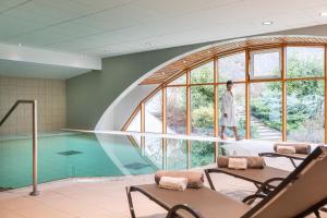 a man standing in a room with a swimming pool at Hotel & Spa Radiana in La Léchère