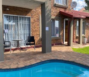 ein Haus mit einem Pool vor einem Haus in der Unterkunft Christa's Place 899 in Pretoria