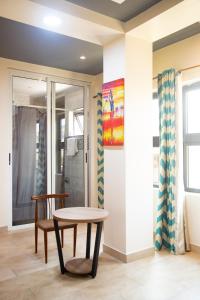 a table and chairs in a room with a shower at IMOLEASE Kouessi Menontin in Cotonou