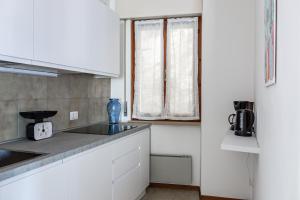 a kitchen with white cabinets and a window at Graziella House in Brenzone sul Garda