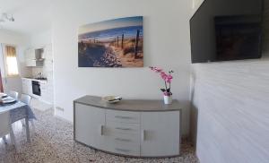 een keuken met een tafel en een schilderij aan de muur bij Appartamenti Da Michela in Cavallino-Treporti