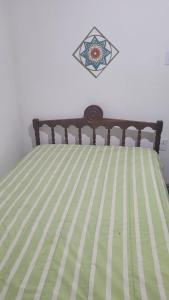 a bed with a green and white striped comforter at Sítio das Valquírias in Taquaraçu