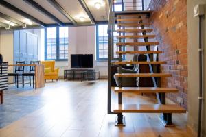a wooden spiral staircase in an office with a brick wall at RedCity LOFT 116 in Żyrardów