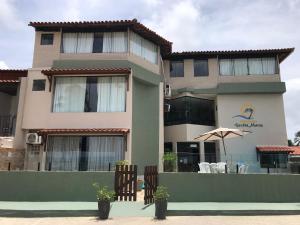 a large building with an umbrella in front of it at Pousada Verdes Mares in Praia do Frances