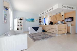 a room with a counter and a woman in a store at Resort Cala La Luna in Favignana