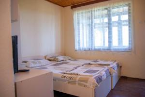 sypialnia z 2 łóżkami i oknem w obiekcie Luccia Apartments - Country House at Monastery Saint Naum w Ochrydzie