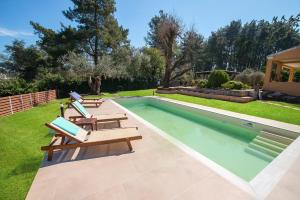 a swimming pool with lounge chairs next to a yard at Spyrelia Villa with Private Pool & Outdoor Hot Tub in Dassia