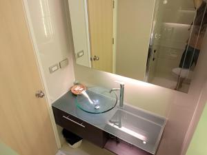 芭達雅南區的住宿－Grande Caribbean Condo Resort Pattaya，一间带玻璃水槽和镜子的浴室