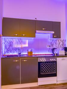 uma cozinha com iluminação roxa e um fogão forno superior em #221 Moderne City Wohnung im Herzen von Neuss em Neuss