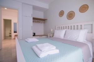 - une chambre blanche avec un lit bleu et des serviettes dans l'établissement Charming Sweet Apt @Garitsa!, à Corfou