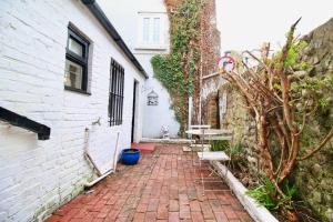 a brick walkway next to a white building at The Little Cottage By Air Premier in Seaford