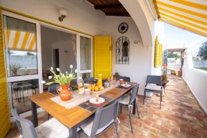 uma sala de jantar com uma mesa de madeira e cadeiras em Villa PACA Algarve Vilamoura 8 personnes em Quarteira
