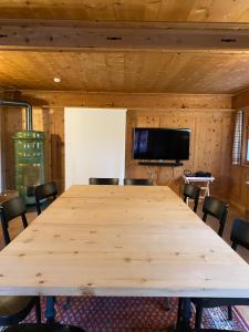 a large wooden table in a room with chairs at Alpengasthof Crusch Alba ed Alvetern, S-charl in Scuol