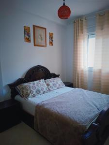 een slaapkamer met een bed en een raam bij Azar immobilier in Oujda