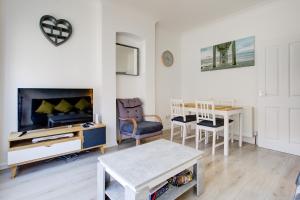 a living room with a tv and a table at Pass the Keys City Beach flat next to the sea sleeps up to 6 in Southend-on-Sea