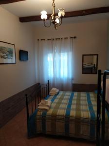 1 dormitorio con cama y lámpara de araña en Il Vigneto "Cottage", en Gaggi