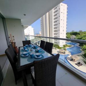Una mesa con platos azules en un balcón. en Torres del Mar Santa Marta, en Santa Marta