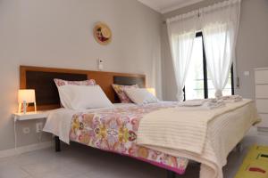Un dormitorio con una cama grande y una ventana en Cartaia Apartamento Leste, en Quarteira