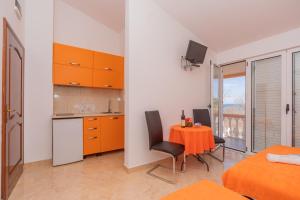 a kitchen and dining room with a table and chairs at Apartmani Milacic in Sutomore