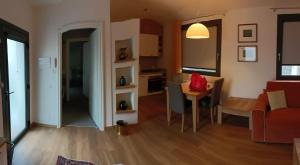 een woonkamer en een keuken met een tafel en een bank bij Appartamento Popone 1 in Aquiléia