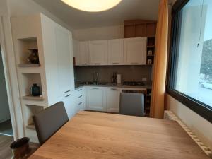 een keuken met een tafel en stoelen en een raam bij Appartamento Popone 1 in Aquiléia