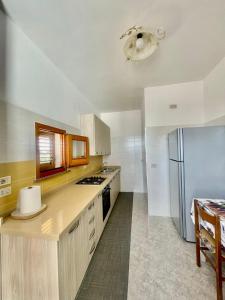 una cucina con armadietti bianchi e frigorifero di Crisimò vacanze a Tiggiano