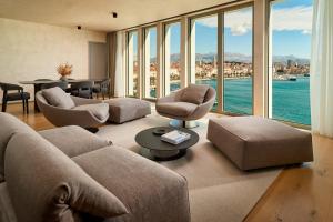 a living room with a couch and chairs and windows at Hotel Ambasador in Split