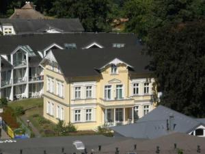 a large yellow house with a black roof at Villa Granitz - Ferienwohnung 45453 (Gellen) in Göhren