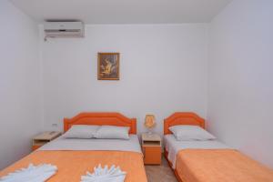 two beds sitting next to each other in a room at Apartmani Milacic in Sutomore