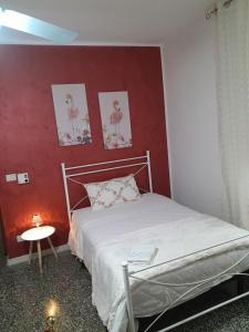 a bedroom with a bed with a red wall at Casa Vacanza Nonna Dora in Matera