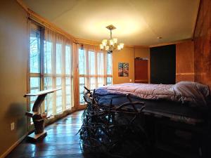 a bedroom with a bed in a room with windows at Lost River Hostel in French Lick
