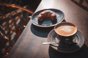 two cups of coffee and a pastry on a table at Villa Sonnenhof Boutique-Hotel in Bad Reichenhall